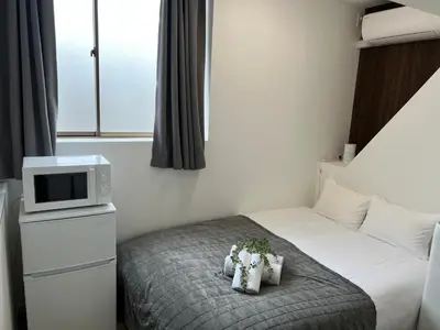a hotel room with a bed and a tv at Ikebukuro Area R1 NishiikeApartment 5F No Elevator in Tokyo