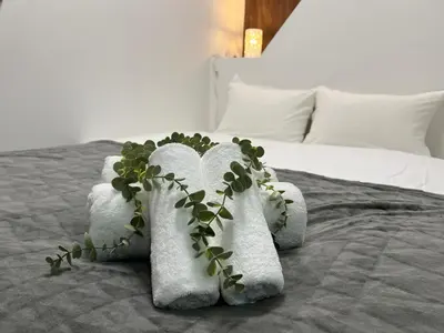 a white towel with a plant on a bed at Ikebukuro Area R1 NishiikeApartment 5F No Elevator in Tokyo