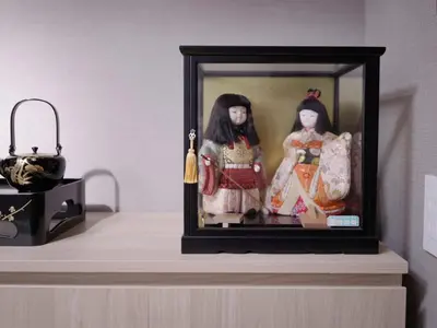 two dolls in a picture frame on a shelf at City Pal Sakurashinmachi - Vacation STAY 17753 in Tokyo