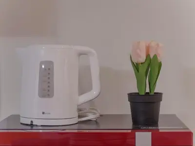 a vase of pink tulips next to a blender at City Pal Sakurashinmachi - Vacation STAY 17753 in Tokyo