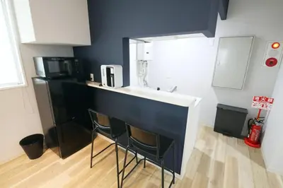 a kitchen with a counter with two chairs and a sink at Hotel TORAKEN in Tokyo