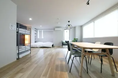 a living room with a table and chairs and a bedroom at Hotel TORAKEN in Tokyo