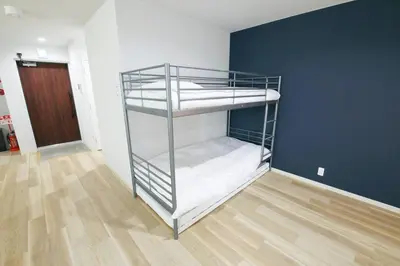 a bunk bed in a room with a wooden floor at Hotel TORAKEN in Tokyo