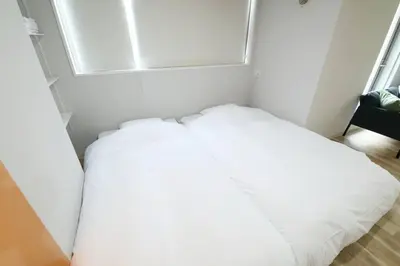 a white bed in a room with a window at Hotel TORAKEN in Tokyo