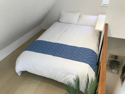 a bedroom with a large bed with blue and white sheets at Honancho Entire house for rent \u6771\u4eac in Tokyo