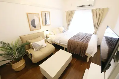a bedroom with a bed and a couch and a chair at \u30b3\u30fc\u30dd\u3071\u3071\u3069\u308c103 in Tokyo