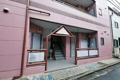 a pink building with a staircase in front of it at \u30b3\u30fc\u30dd\u3071\u3071\u3069\u308c103 in Tokyo