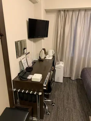 a hotel room with a desk with a phone at Ochanomizu Inn in Tokyo