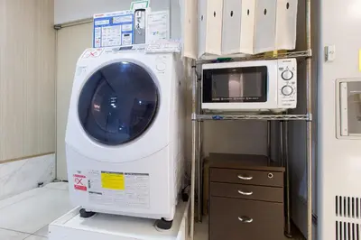 a washing machine and a microwave in a room at Ochanomizu Inn in Tokyo