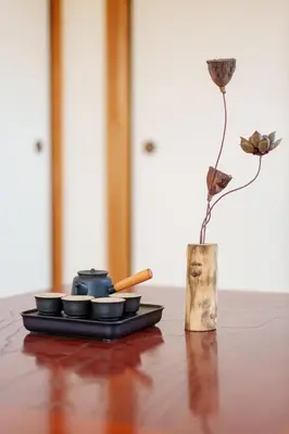 a table with a plate and a vase with a flower at \u9759\u5fc3\u5bbf Tranquil Retreat 3F \u6674\u7a7a\u5854Sensoji\u76f4\u8fbe in Tokyo