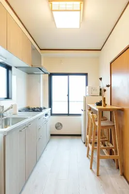 a kitchen with a table and a refrigerator at \u9759\u5fc3\u5bbf Tranquil Retreat 3F \u6674\u7a7a\u5854Sensoji\u76f4\u8fbe in Tokyo