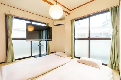 two beds in a room with a large window at \u9759\u5fc3\u5bbf Tranquil Retreat 2F in Tokyo