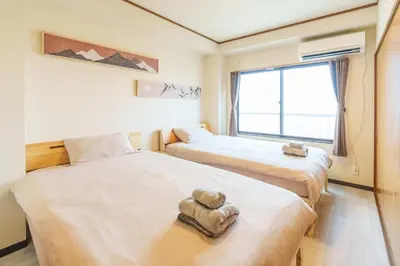 a room with two beds with towels on them at \u9759\u5fc3\u5bbf Tranquil Retreat 2F in Tokyo