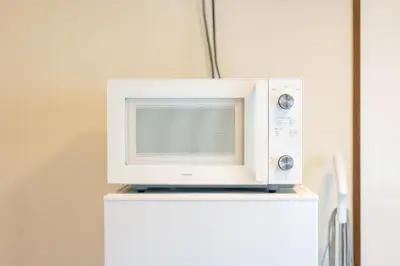 a microwave sitting on top of a refrigerator at \u9759\u5fc3\u5bbf Tranquil Retreat 2F in Tokyo