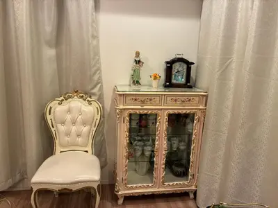 a chair next to a cabinet and a clock at \u30c7\u30a3\u30a2\u30d8\u30c3\u30c9\u897f\u4e00\u4e4b\u6c5f in Tokyo