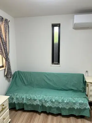 a green bed in a room with a window at \u30c7\u30a3\u30a2\u30d8\u30c3\u30c9\u897f\u4e00\u4e4b\u6c5f in Tokyo