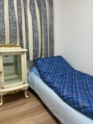 a bed with a night stand next to a wall at \u30c7\u30a3\u30a2\u30d8\u30c3\u30c9\u897f\u4e00\u4e4b\u6c5f in Tokyo