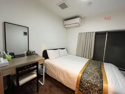 a bedroom with a bed and a desk and a mirror at \u82b1\u4e43\u90f7 \u7530\u7aefab in Tokyo