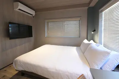 a bedroom with a white bed and a window at Rakuna Inn \u6674 Kinshi2 in Tokyo