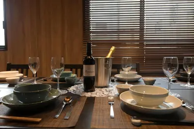 a wooden table with a bottle of wine and glasses at Rakuna Inn \u6674 Kinshi2 in Tokyo