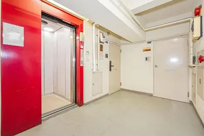an empty corridor in a hospital with a red door at Sakura Suite in Tokyo