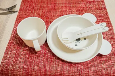 two white plates and a cup on a red table at Sakura Suite in Tokyo