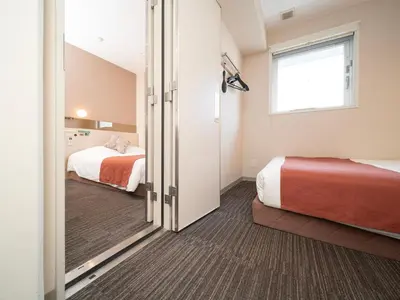 a hotel room with two beds and a window at Super Hotel Premier Akasaka in Tokyo