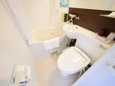 a bathroom with a toilet and a sink and a tub at Super Hotel Premier Akasaka in Tokyo