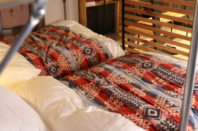 a bed with a blanket on top of it at \u30ef\u30f3\u30d5\u30ed\u30a2\u8cb8\u5207\u30c7\u30b6\u30a4\u30ca\u30fc\u30ba\u30eb\u30fc\u30e0 \u65b0\u5bbf\u307e\u306710\u5206 in Tokyo