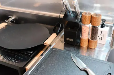 a frying pan on top of a stove with a knife at \u30ef\u30f3\u30d5\u30ed\u30a2\u8cb8\u5207\u30c7\u30b6\u30a4\u30ca\u30fc\u30ba\u30eb\u30fc\u30e0 \u65b0\u5bbf\u307e\u306710\u5206 in Tokyo