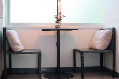 a table and two chairs sitting under a window at \u30ef\u30f3\u30d5\u30ed\u30a2\u8cb8\u5207\u30c7\u30b6\u30a4\u30ca\u30fc\u30ba\u30eb\u30fc\u30e0 \u65b0\u5bbf\u307e\u306710\u5206 in Tokyo
