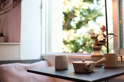 a coffee table with cups and a vase on it at \u30ef\u30f3\u30d5\u30ed\u30a2\u8cb8\u5207\u30c7\u30b6\u30a4\u30ca\u30fc\u30ba\u30eb\u30fc\u30e0 \u65b0\u5bbf\u307e\u306710\u5206 in Tokyo