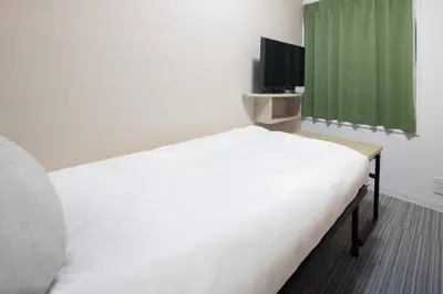 a bedroom with a white bed and a television at CH RESiDENCE \u65e9\u7a32\u7530\u9db4\u5dfb\u753a in Tokyo