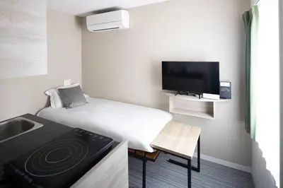 a small room with a bed and a flat screen tv at CH RESiDENCE \u65e9\u7a32\u7530\u9db4\u5dfb\u753a in Tokyo