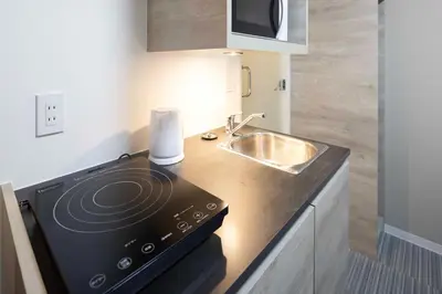 a small kitchen with a stove and a sink at CH RESiDENCE \u65e9\u7a32\u7530\u9db4\u5dfb\u753a in Tokyo