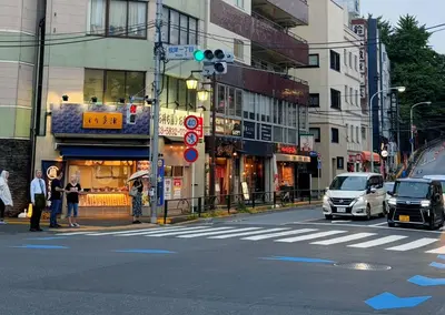 a busy city street with a traffic light and buildings at LoveTokyo Easy Access Nezu Sunset House \u6839\u6d25\u99c5\u5f92\u6b691\u5206 \u30a8\u30ec\u30d9\u30fc\u30bf\u30fc \u4e0a\u91ce \u8c37\u4e2d\u9280\u5ea7 \u6839\u6d25\u795e\u793e \u6771\u4eac\u5927\u5b66 \u65b0\u5bbf \u6e0b\u8c37 \u9280\u5ea7 \u7bc9\u5730 \u539f\u5bbf\u8fd1\u3044 in Tokyo
