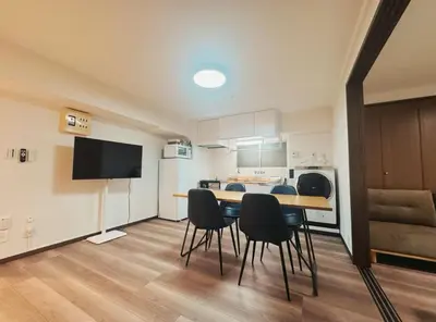 a room with a table and chairs and a kitchen at LoveTokyo Easy Access Nezu Sunset House \u6839\u6d25\u99c5\u5f92\u6b691\u5206 \u30a8\u30ec\u30d9\u30fc\u30bf\u30fc \u4e0a\u91ce \u8c37\u4e2d\u9280\u5ea7 \u6839\u6d25\u795e\u793e \u6771\u4eac\u5927\u5b66 \u65b0\u5bbf \u6e0b\u8c37 \u9280\u5ea7 \u7bc9\u5730 \u539f\u5bbf\u8fd1\u3044 in Tokyo