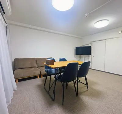 a room with a table and chairs and a couch at LoveTokyo Easy Access Nezu Sunset House \u6839\u6d25\u99c5\u5f92\u6b691\u5206 \u30a8\u30ec\u30d9\u30fc\u30bf\u30fc \u4e0a\u91ce \u8c37\u4e2d\u9280\u5ea7 \u6839\u6d25\u795e\u793e \u6771\u4eac\u5927\u5b66 \u65b0\u5bbf \u6e0b\u8c37 \u9280\u5ea7 \u7bc9\u5730 \u539f\u5bbf\u8fd1\u3044 in Tokyo