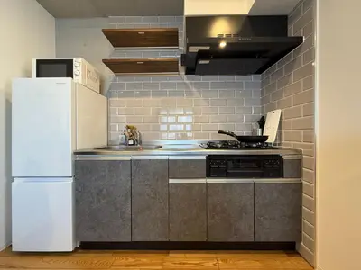 a kitchen with a white refrigerator and a sink at nestay inn tokyo skytree in Tokyo