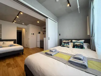 a bedroom with two beds with towels on them at nestay inn tokyo skytree in Tokyo