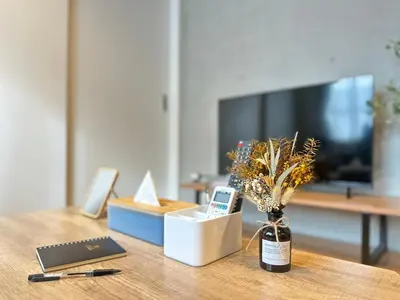 a wooden table with a vase with flowers on it at nestay inn tokyo skytree in Tokyo