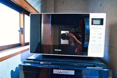 a person taking a picture in a microwave at Tokyo Oasis Heiwajima in Tokyo