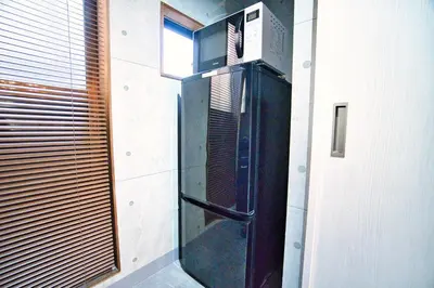 a kitchen with a microwave on a wall at Tokyo Oasis Heiwajima in Tokyo