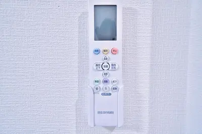 a white remote control hanging on a wall at Tokyo Oasis Heiwajima in Tokyo