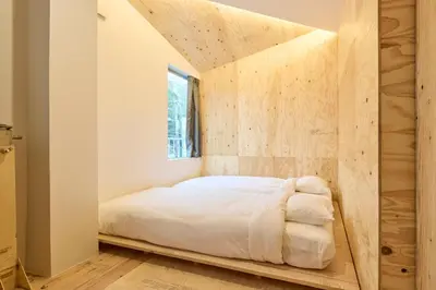 a bed in a room with a wooden wall at SHORTsuido in Tokyo