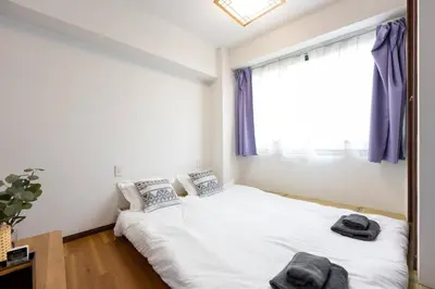 a bedroom with a bed and a window with purple curtains at \u4eca\u548cHotel in Tokyo