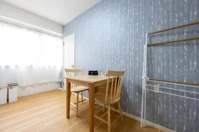 a table and chairs in a room with a blue wall at \u4eca\u548cHotel in Tokyo