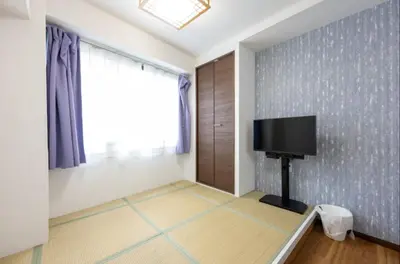 a living room with a tv on a wall at \u4eca\u548cHotel in Tokyo