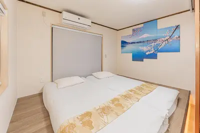 a bedroom with two beds and a large window at Family House \u857e \u6c60\u888b\u5f92\u6b65\u5708\u5168\u65b0\u88c5\u4fee\u65e5\u5f0f\u6237\u5efa\u6c11\u5bbf in Tokyo