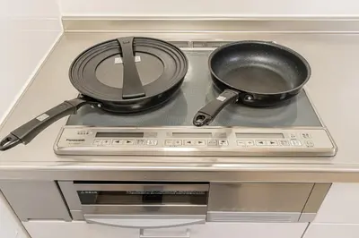 two pans sitting on top of a stove at Family House \u857e \u6c60\u888b\u5f92\u6b65\u5708\u5168\u65b0\u88c5\u4fee\u65e5\u5f0f\u6237\u5efa\u6c11\u5bbf in Tokyo